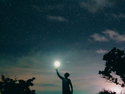 boy holding idea light in starry sky